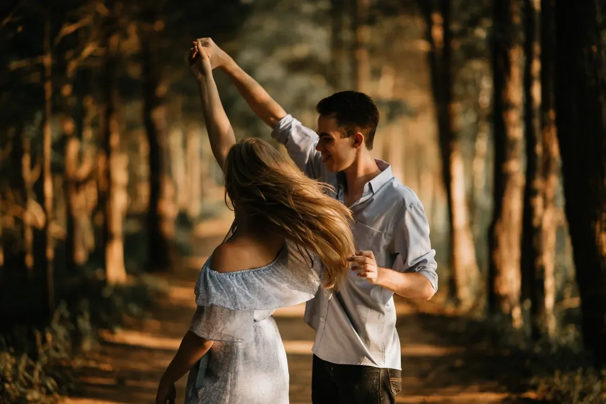 A couple dancing among trees in evening light